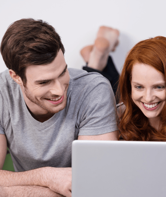 Happy couple with laptop | Montgomery's CarpetsPlus COLORTILE